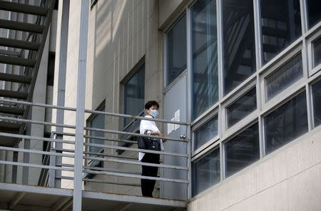 A hospital employee wearing a mask to prevent contracting Middle East Respiratory Syndrome (MERS) waits outside a closed door at a hospital which is sealed off temporarily, in Seoul, South Korea, June 16, 2015. REUTERS/Kim Hong-Ji