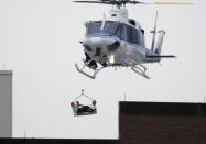 A helicopter pulls what appears to be a shooting victim up as it hovers over a rooftop on the Washington Navy Yard campus in Washington, September 16, 2013. The U.S. Navy said several people were injured and there were possible fatalities in the shooting at the Navy Yard in Washington D.C. on Monday. The Navy did not immediately provide additional details but a Washington police spokesman said earlier that five people had been shot, including a District of Columbia police officer and one other law enforcement officer. (REUTERS/Jason Reed)