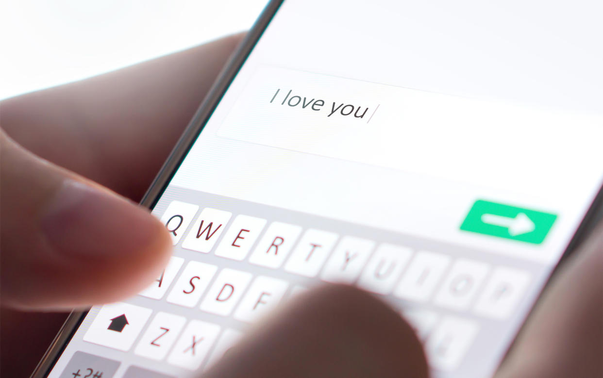Sending I love you text message with mobile phone. 