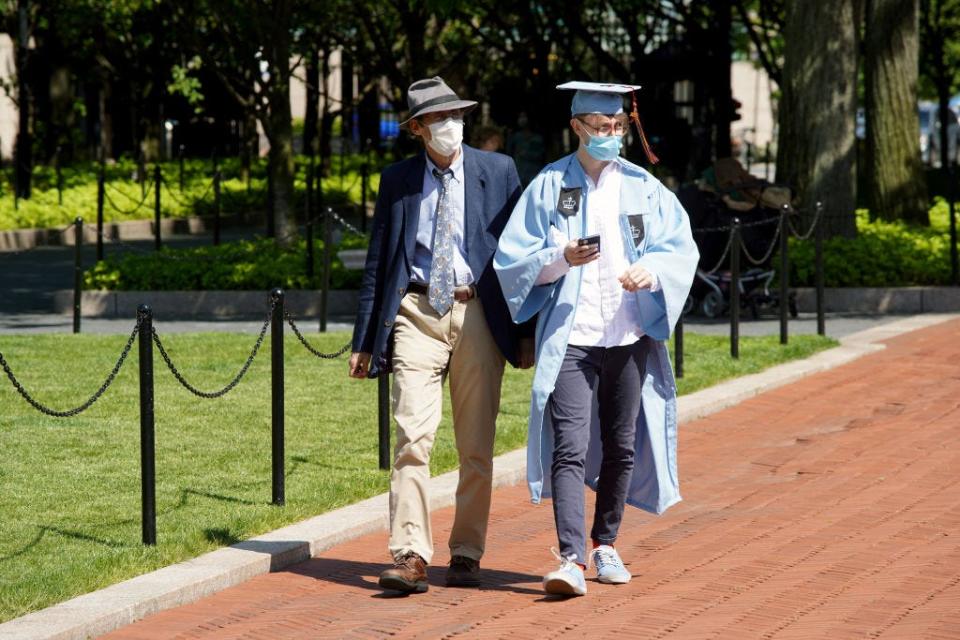 A graduate wearing a cap, gown and protective face mask is seen on the campus of Columbia University on May 21, 2020 in New York City. 