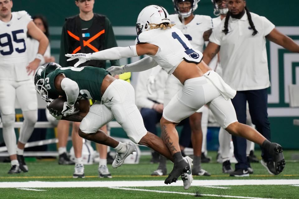 Michigan State wide receiver Montorie Foster Jr. is pushed out of bounds by Penn State safety Jaylen Reed during the first half on Friday, Nov. 24, 2023, at Ford Field.