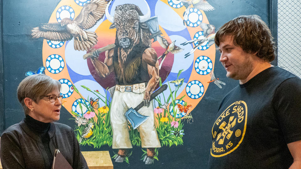 Gov. Laura Kelly talks with Calebh Shedd, owner of the Axe Shedd, during an April 25, 2024, visit to Emporia