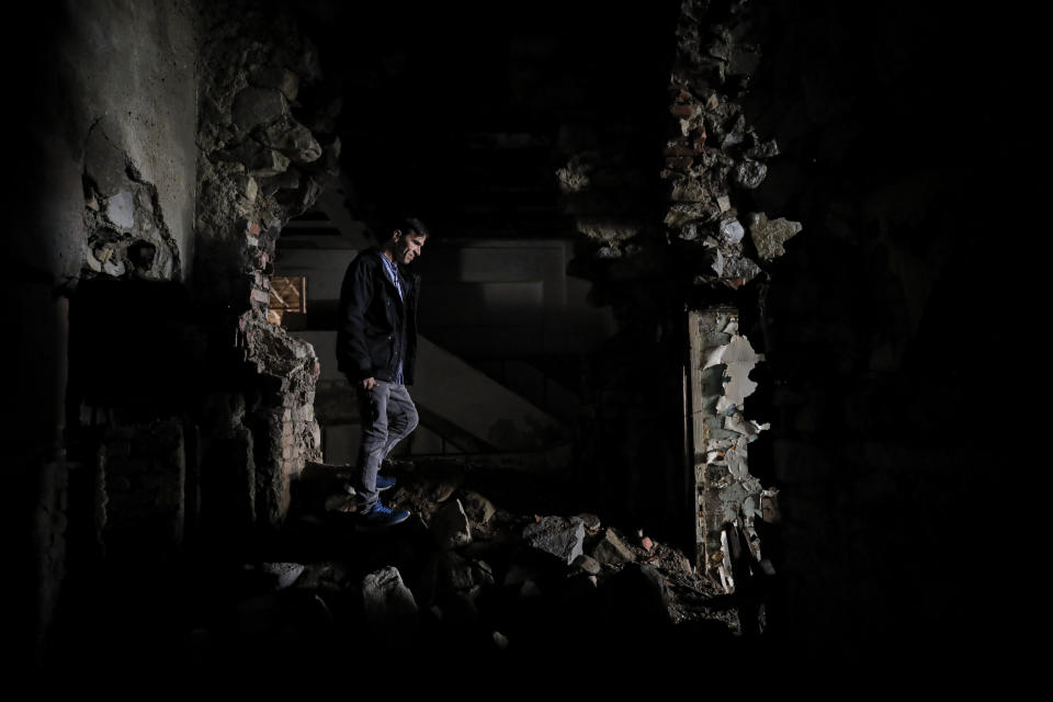In this photo taken on Monday, Dec. 16, 2019, Florin Catanescu, 41, walks through the ruins of the state orphanage that was his home between 1988 and 1997 in Busteni, Romania. Thirty years after the 1989 death of Romania's communist-era dictator, the country is still grappling with the ugly legacy of its once-horrific orphanages. Now some of those who grew up abused and unloved in those failed institutions are turning their trauma into commitment. Florin Catanescu, who lived in an orphanage until 1997, now runs a transition home helping those leaving state care to have a better chance of leading meaningful lives. (AP Photo/Vadim Ghirda)