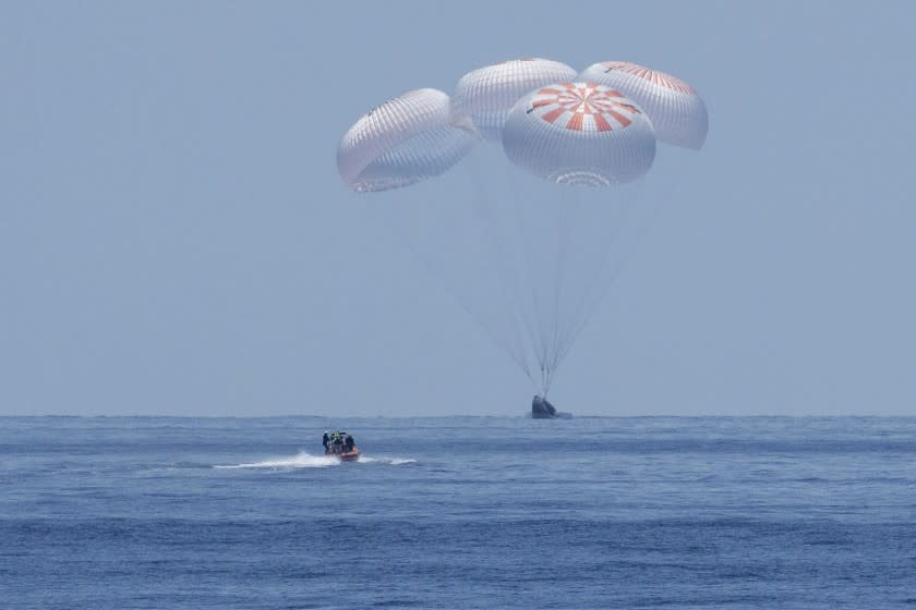 The SpaceX Crew Dragon Endeavour spacecraft lands with NASA astronauts Robert Behnken and Douglas Hurley onboard in the Gulf of Mexico off the coast of Pensacola, Fla., Sunday, Aug. 2, 2020. It s the first splashdown in 45 years for NASA astronauts and the first time a private company has ferried people from orbit. (Bill Ingalls/NASA via AP)