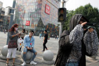 A man holds a rose in the Sanlitun shopping district in Beijing, China May 15, 2019. REUTERS/Thomas Peter