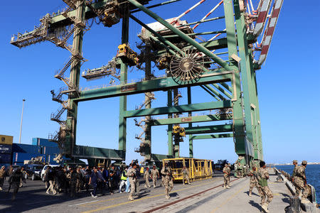 Soldiers escort government officials touring the container terminal at Aden port, Yemen December 12, 2018 . REUTERS/Fawaz Salman