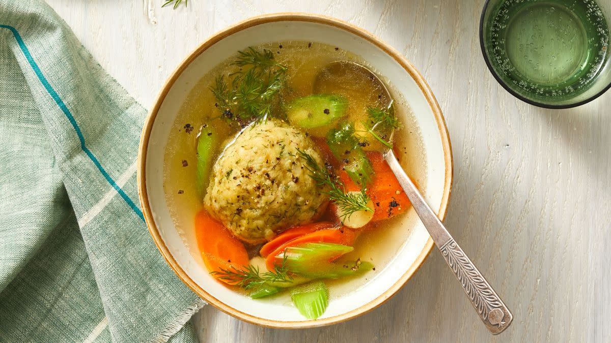 matzo ball soup in a bowl with carrots and celery