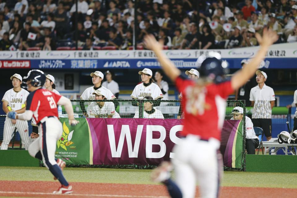 Japan's players, in white jersey, react to a walk-off loss as U.S. team members, in red jersey, celebrate during Women's Softball World Championship game Saturday Aug. 11, 2018 in Makuhari, east of Tokyo. United States to a 4-3 win over Japan and into the final of the women's world softball championship. (Kyodo News via AP)