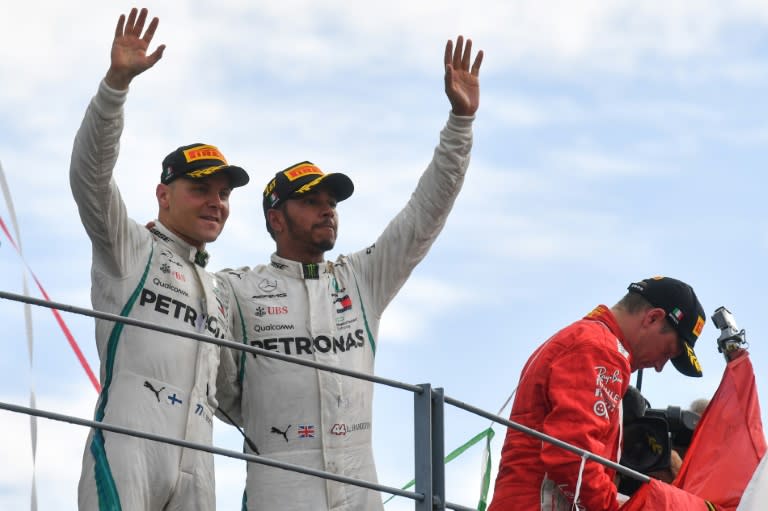 Mercedes' British driver Lewis Hamilton (C) and team-mate and third-placed Finnish teammate Valtteri Bottas celebrate on the podium after the Italian Formula One Grand Prix at the Autodromo Nazionale circuit in Monza on September 2, 2018