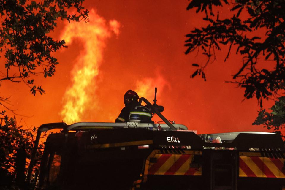 Firefighters attempt to control a forest fire spread on the communes of Landiras and Guillos, southwestern France, on July 13, 2022. - A fire in progress since Tuesday afternoon has burned 600 hectares of pine forest near Landiras (Gironde), some 40 km south of Bordeaux, leading to the evacuation of 150 people, the prefecture said. (Photo by Thibaud MORITZ / AFP) (Photo by THIBAUD MORITZ/AFP via Getty Images)