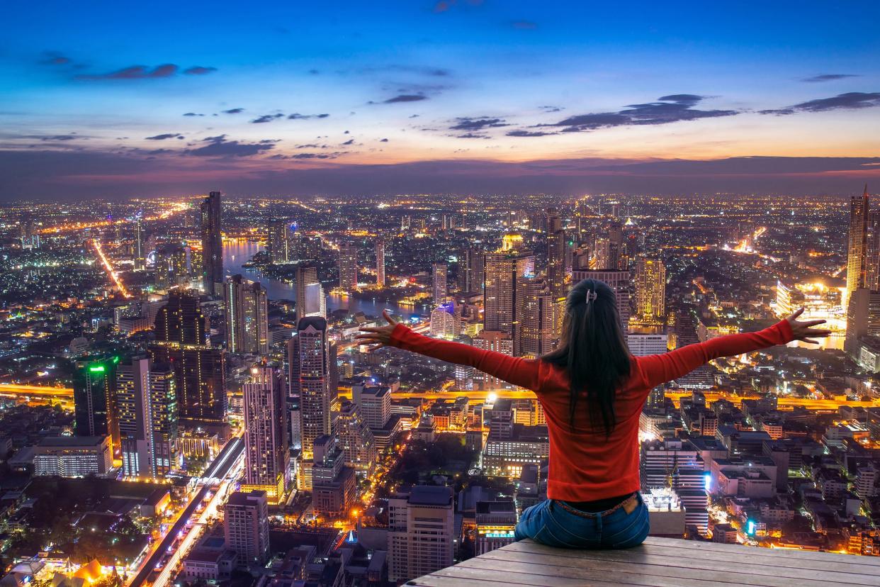 woman happy enjoying the city view from top of a city at twilight