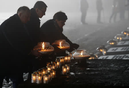(L-R) Undersecretary of State at the Chancellery of the President of Poland Wojciech Kolarski, Polish Prime Minister Mateusz Morawiecki and deputy Prime Minister Beata Szydlo place candles at the Monument to the Victims at the former Nazi German concentration and extermination camp Auschwitz II-Birkenau, during the ceremonies marking the 73rd anniversary of the liberation of the camp and International Holocaust Victims Remembrance Day, near Oswiecim, Poland, January 27, 2018. REUTERS/Kacper Pempel