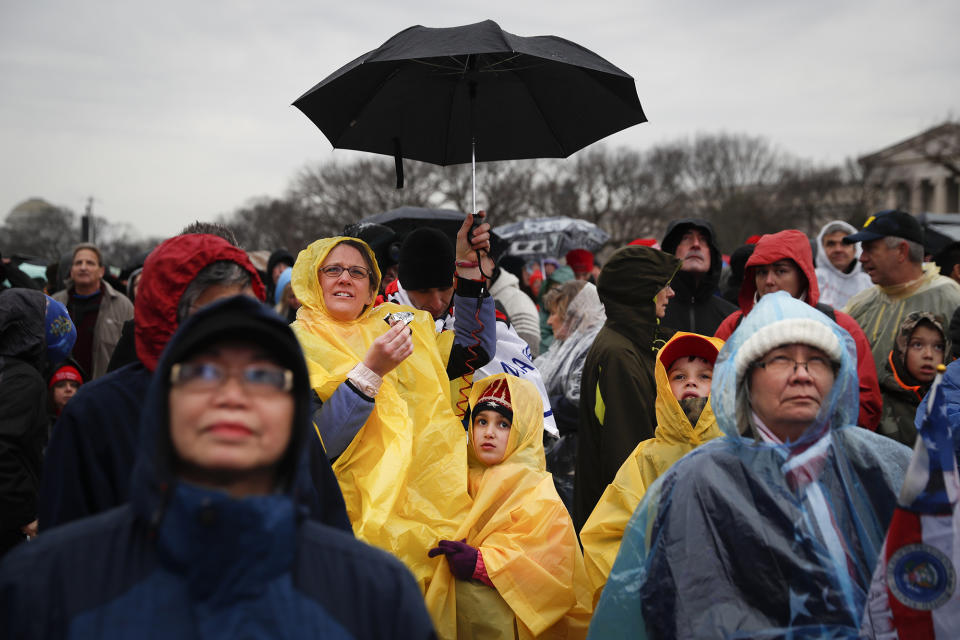 <p>Spectators wait in the rain on the National Mall in Washington, Friday, Jan. 20, 2017, before the presidential inauguration of Donald Trump. (Photo: John Minchillo/AP) </p>