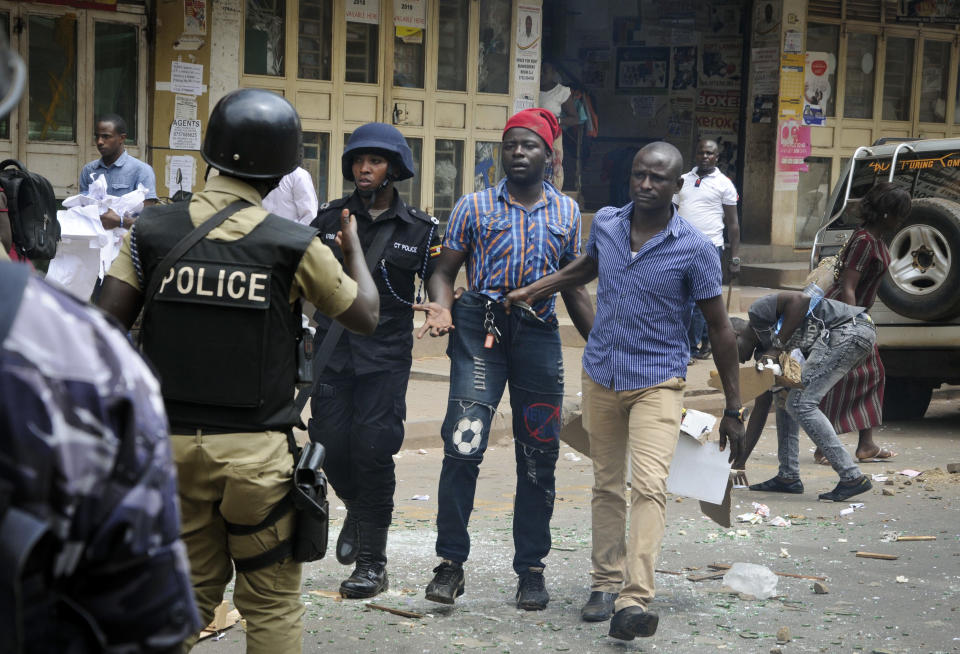 Ugandan security forces detain a protester in Kampala, Uganda, Monday, Aug. 20, 2018. Ugandan police fired bullets and tear gas to disperse a crowd of protesters demanding the release of jailed lawmaker, pop star, and government critic Kyagulanyi Ssentamu, whose stage name is Bobi Wine. (AP Photo/Ronald Kabuubi)