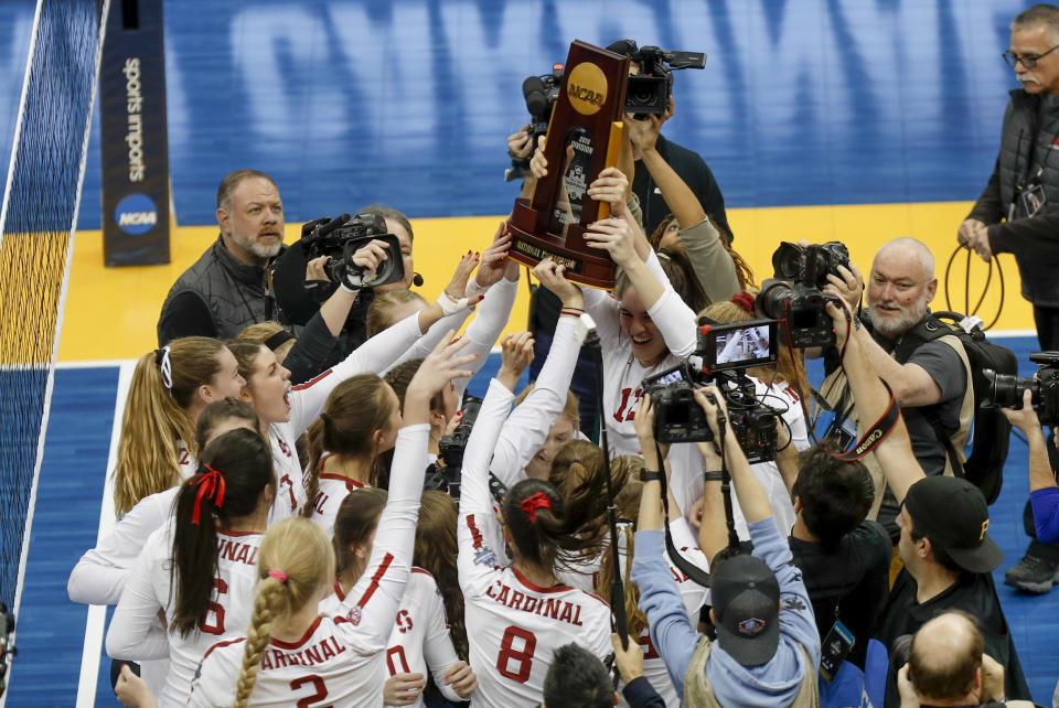 FILE - The Stanford women's volleyball team holds the championship trophy overhead after defeating Wisconsin for the NCAA Division I women's volleyball championship, in Pittsburgh, in this Saturday, Dec. 21, 2019, file photo. Women's volleyball will be the first of the NCAA fall sports to play this spring after the COVID-19 pandemic prompted most conferences to cancel or shorten their 2020 fall seasons and the NCAA to call off the national tournament. (AP Photo/Keith Srakocic, File)