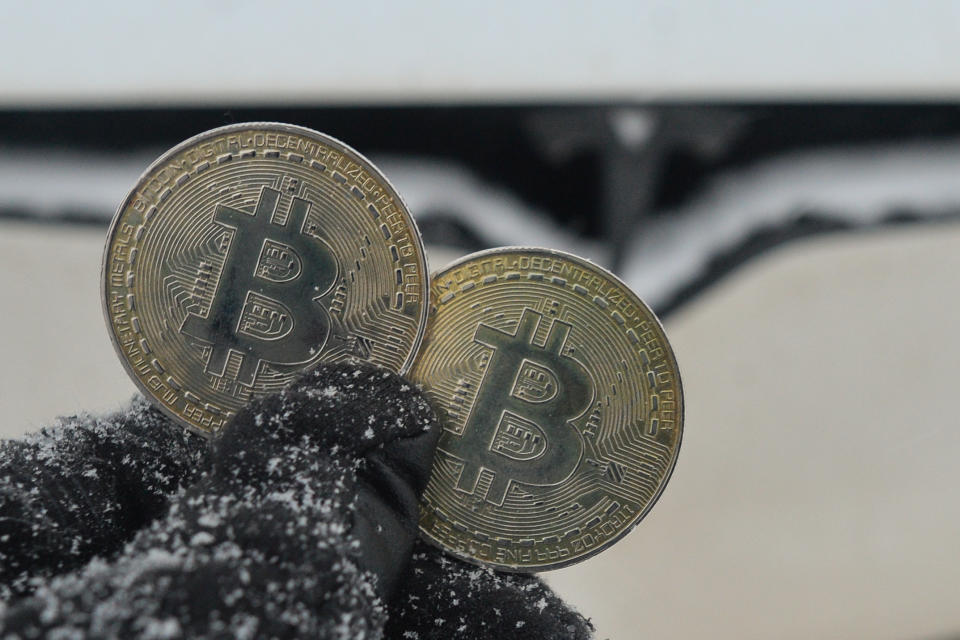 Illustrative image of two commemorative bitcoins seen in front of the Tesla car during a cold weather 
On Friday, January 7, 2022, in Edmonton, Alberta, Canada. (Photo by Artur Widak/NurPhoto via Getty Images)