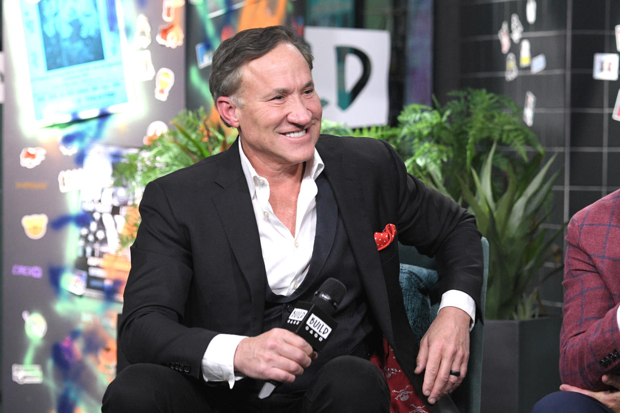 Terry Dubrow holds a microphone on set.