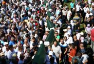 People carry coffins during a mass funeral in the village of Hambarine