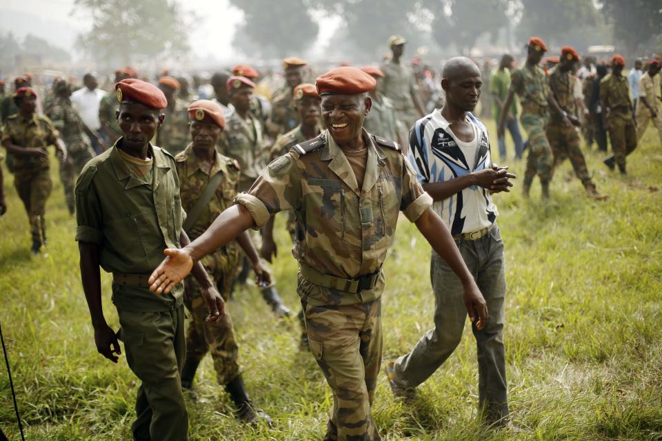 Newly enlisted FACA (Central African Armed Forces) soldiers smile after listening to Central African Republic Interim President Catherine Samba-Panza addressing the troops in Bangui, Wednesday Feb. 5, 2014. Moments later, they lynched and killed a suspected Muslim Seleka militiaman in front of African Union troops who made no effort to stop the killing. (AP Photo/Jerome Delay)