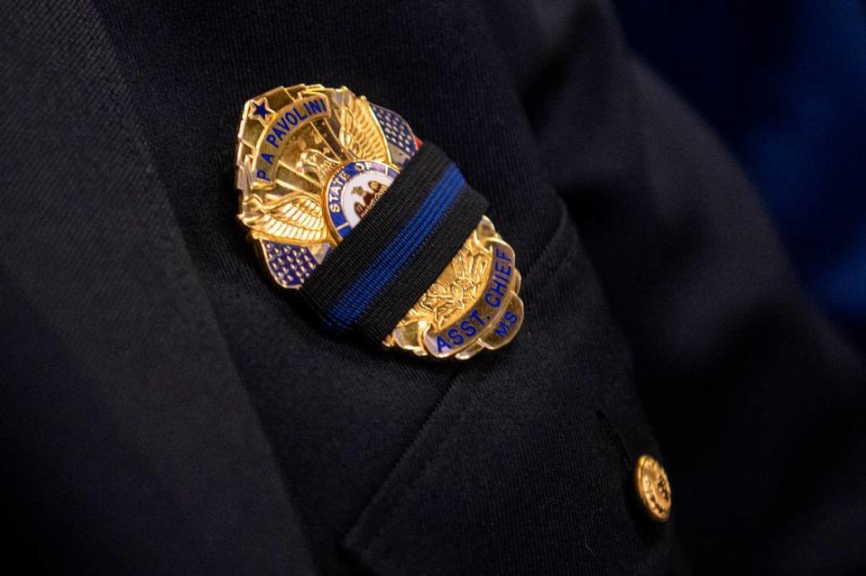 Waveland Assistant Police Chief Philip Pavolini wears a bland band over his badge during the funeral for Bay St. Louis police officers Sgt. Steven Robin and Branden Estorffe at the Bay St. Louis Community Center in Bay St. Louis on Wednesday, Dec. 21, 2022.