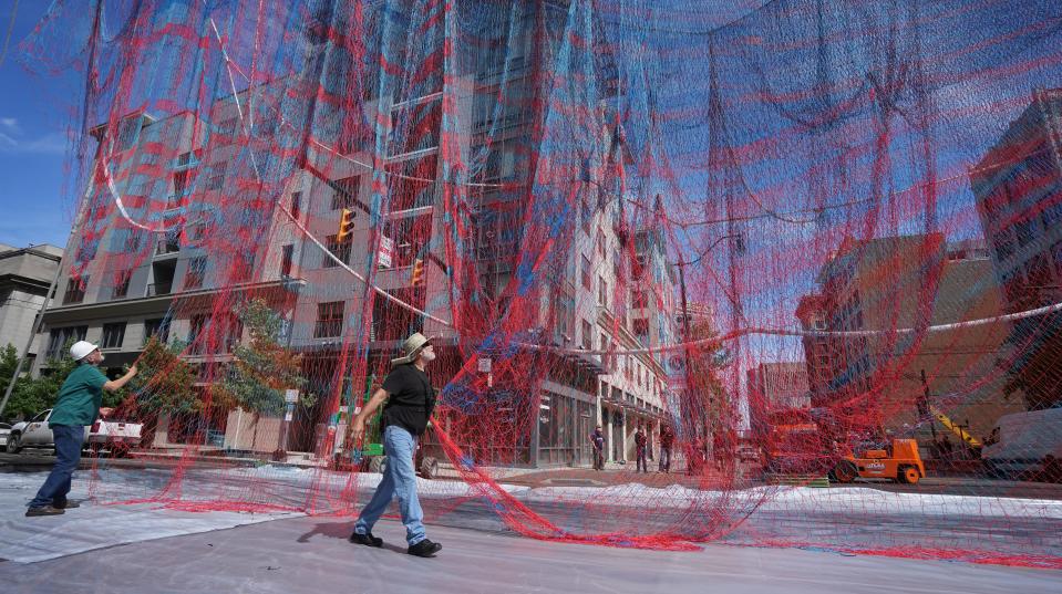 Greg Jones (left) and Tom George unravel the strings of Current, a nylon art installation that hangs above the North High Street and Gay Street intersection Downtown. Jones is with the Columbus Museum of Art; George is with Suspension Dimension.