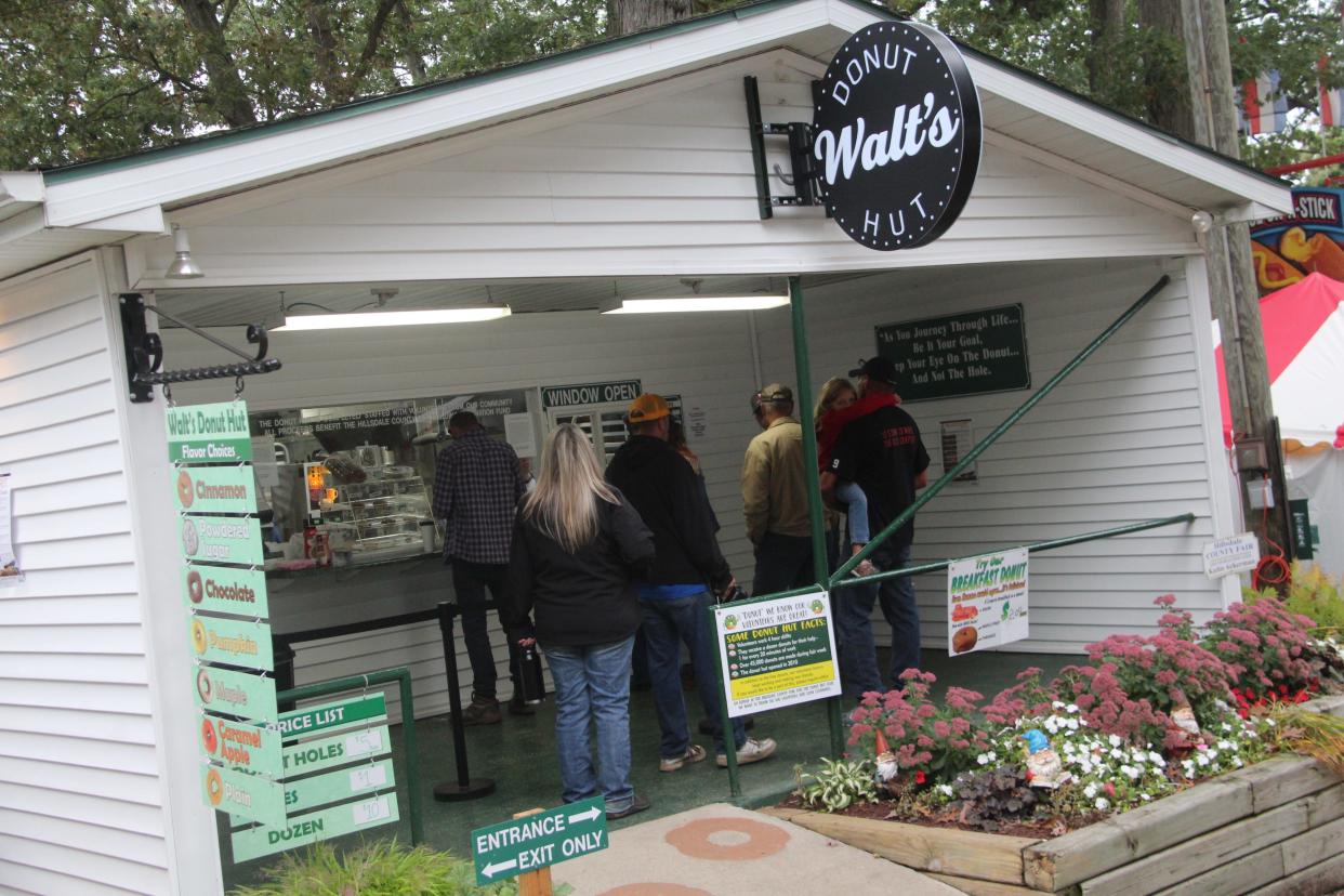 Patrons line up to purchase doughnuts from the newly annointed Walt's Donut Hut inside the Hillsdale County Fairgrounds.