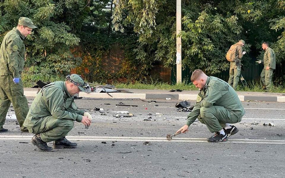 Investigators work on the site of explosion of a car driven by Daria Dugina