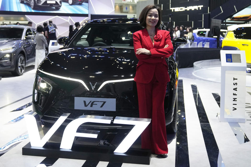 Vu Dang Yen Hang, chief executive officer of VinFast Thailand, poses in front of its electric vehicle VF7 during the 45th Bangkok Motor Show in Nonthaburi, Thailand, Tuesday, March 26, 2024. (AP Photo/Sakchai Lalit)