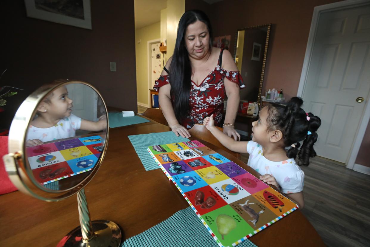Soody Martinez gets a thumbs-up from her daughter Ashely, 3, who was getting all her colors correct as she practiced her English using one of her books from her pre-kindergarten class, in the family's apartment in Rochester Friday, Jan. 26, 2024.