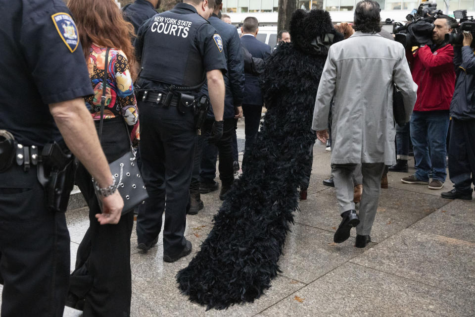 Rapper Cardi B wears a black coat with a long train as she leaves Queens Criminal Court after a hearing, Tuesday, Dec. 10, 2019 in New York. (AP Photo/Mark Lennihan)