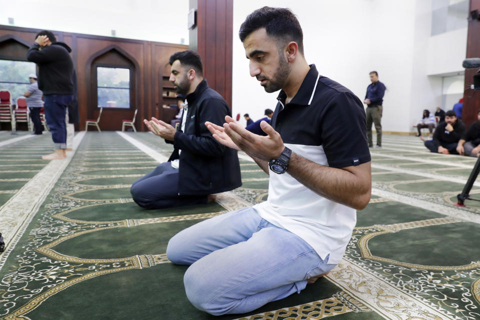 Brothers Samiullah Safi, left, and Abdul Wasi Safi, right, pray during Friday prayers at the Al-Noor Society Mosque in Houston, on April 7, 2023. Abdul, who had suffered injuries while assisting the U.S. military in Afghanistan during the war, has recently arrived in Houston after being detained for months, but has no documentation allowing him to begin a normal life with his brother. (AP Photo/Michael Wyke)