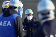 International Atomic Energy Agency Director General Rafael Mariano Grossi, center, is guided at a facility for the sampling treated and diluted radioactive water to sea from the Fukushima Daiichi nuclear power plant, operated by Tokyo Electric Power Company Holdings (TEPCO), in Futaba town, northeastern Japan, Wednesday, March 13, 2024. (AP Photo/Eugene Hoshiko, Pool)