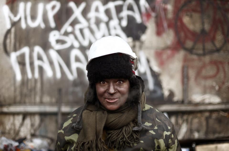 Anti-government protester whose face is covered in soot is pictured at a barricade in Kiev