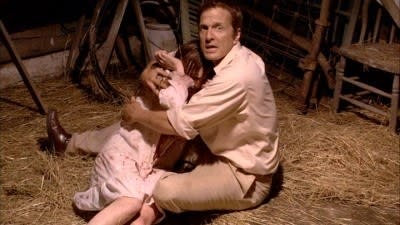 Man sits in hay hugging a possessed girl