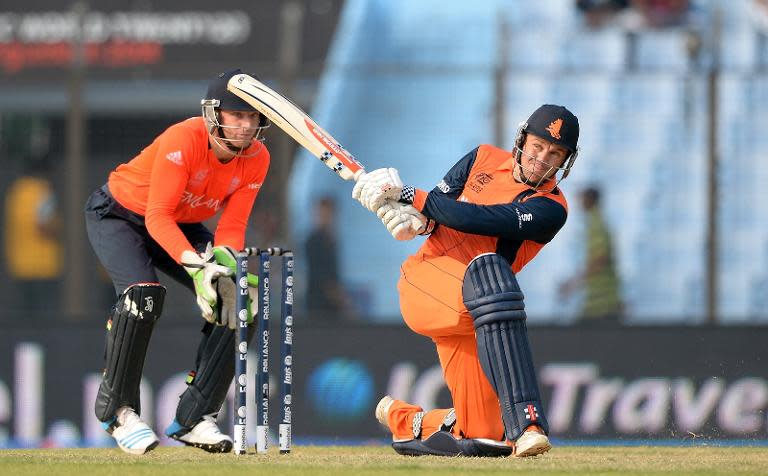 England wicketkeeper Jos Buttler (left) watches as Netherlands batsman Stephan Myburgh hits a six during the ICC World Twenty20 match between the Netherlands and England at the Zahur Ahmed Chowdhury Stadium in Chittagong on March 31, 2014