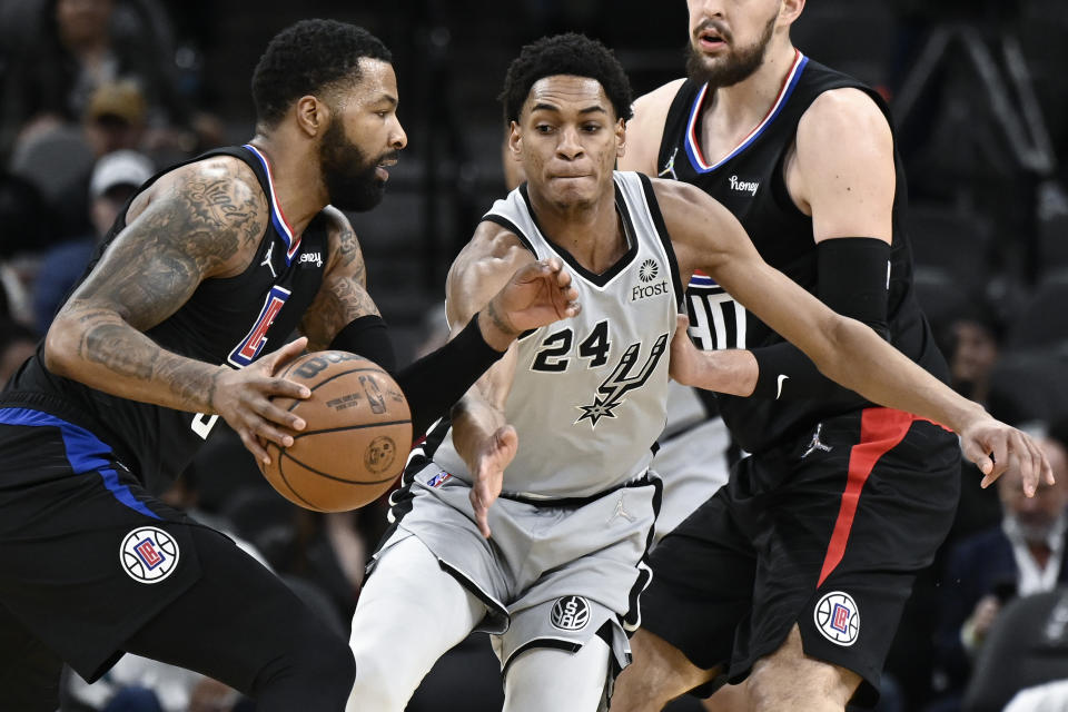 Los Angeles Clippers' Marcus Morris, Sr., left, drives against San Antonio Spurs' Devin Vassell during the first half of an NBA basketball game, Saturday, Jan. 15, 2022, in San Antonio. (AP Photo/Darren Abate)