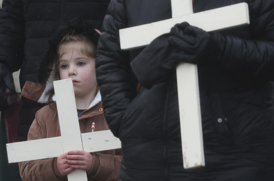 People take part in a march holding crosses to commemorate the victims of Bloody Sunday during a march on the 50th anniversary of the 'Bloody Sunday' shootings in Londonderry, Sunday, Jan. 30, 2022. In 1972 British soldiers shot 28 unarmed civilians at a civil rights march, killing 13 on what is known as Bloody Sunday or the Bogside Massacre. Sunday marks the 50th anniversary of the shootings in the Bogside area of Londonderry .(AP Photo/Peter Morrison)