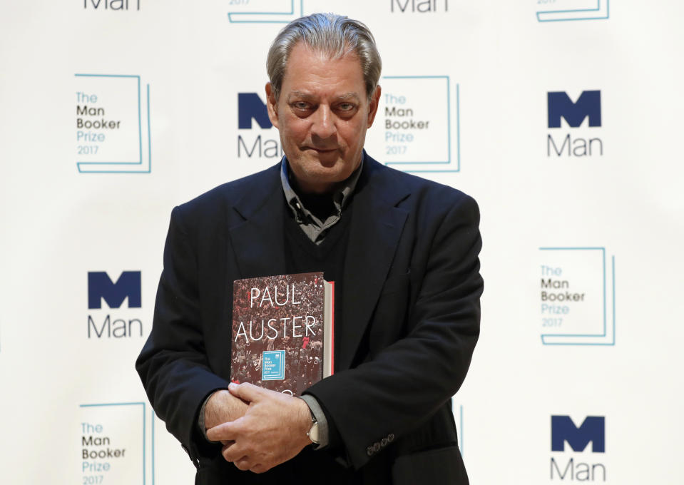 FILE - U.S. author Paul Auster poses with his book "4321" during a photocall with all six shortlisted authors of the 2017 Man Booker Prize for Fiction, in London, Oct. 16, 2017. Paul Auster, a prolific, prize-winning man of letters and filmmaker known for such inventive narratives and meta-narratives as “The New York Trilogy” and “4 3 2 1,” has died at age 77. (AP Photo/Kirsty Wigglesworth, File)