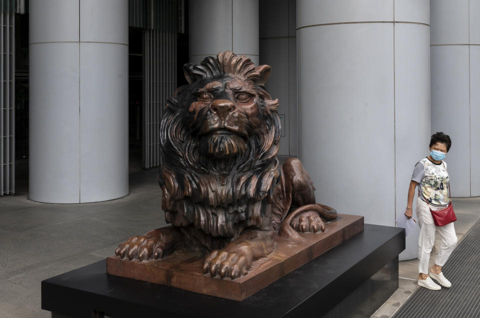 HONG KONG, CHINA - 2020/10/23: A woman walks past a bronze lion statue, restored after pro-democracy protesters vandalized it, outside the HSBC (The Hongkong and Shanghai Banking Corporation) headquarters building. (Photo by Miguel Candela/SOPA Images/LightRocket via Getty Images)