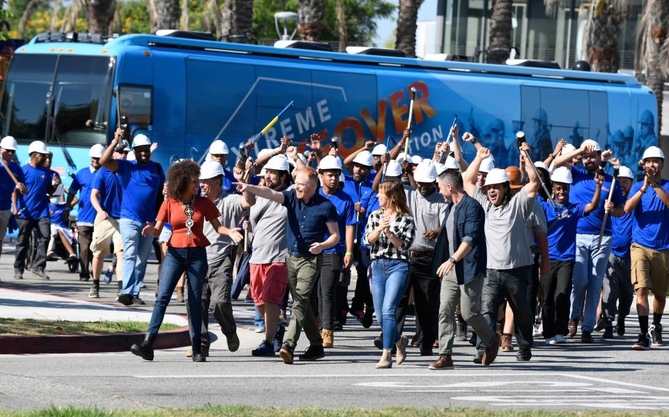 Host Jesse Tyler Ferguson leads the charge with designers Breegan Jane, Carrie Locklyn, Darren Keefe, as volunteers march to see the Washington family in West Athens, California on an episode of "Extreme Makeover: Home Edition."