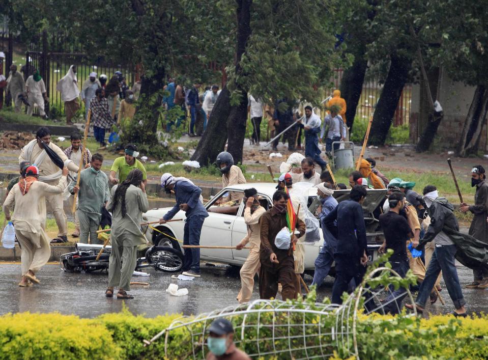 Supporters of Tahir ul-Qadri, Sufi cleric and leader of political party Pakistan Awami Tehreek (PAT), use sticks to hit a car and a motorcycle as they protest during Revolution March towards the prime minister's house in Islamabad September 1, 2014. (EUTERS/Faisal Mahmood)