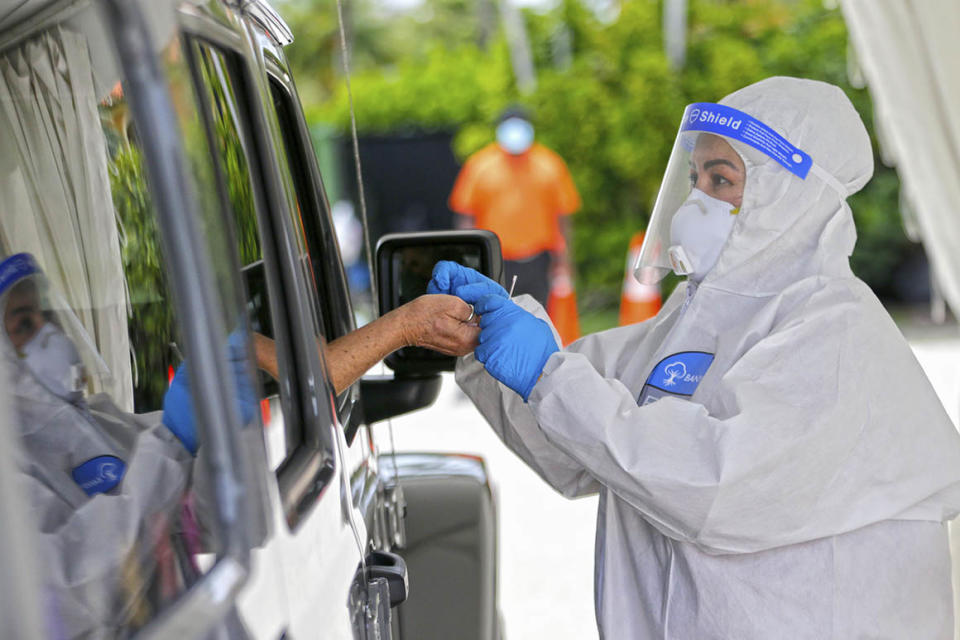 Health workers perform coronavirus antibody testing at a drive-thru site in Bal Harbour, Fla.