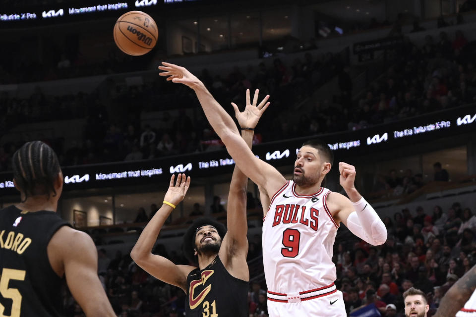 Chicago Bulls center Nikola Vucevic (9) tips the ball away from Cleveland Cavaliers center Jarrett Allen (31) during the first half of an NBA basketball game Saturday, Dec. 23, 2023, in Chicago. (AP Photo/Matt Marton)