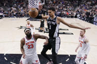 San Antonio Spurs center Victor Wembanyama (1) scores one rNew York Knicks center Mitchell Robinson (23) during overtime in an NBA basketball game in San Antonio, Friday, March 29, 2024. (AP Photo/Eric Gay)