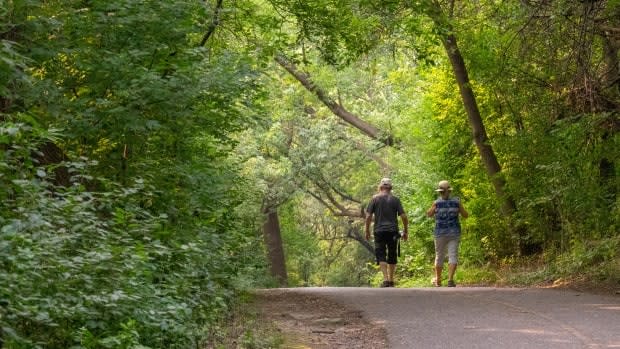 Two people walk near the Ottawa River on July 18. (Francis Ferland/CBC - image credit)