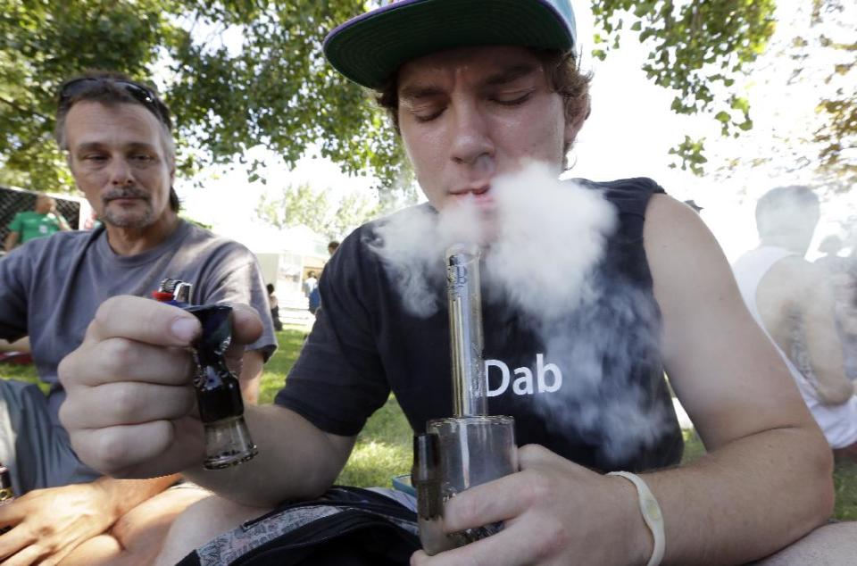 FILE - In this Aug. 16, 2013, file photo, Cody Park exhales a cloud of marijuana smoke after taking a hit from a bong at the first day of Hempfest in Seattle. Nationwide marijuana legalization seems inevitable to three-fourths of Americans, whether they support it or not, according to a new poll out Wednesday, April 2, 2014, by the Pew Research Center on the nation’s shifting attitudes about drug policy. (AP Photo/Elaine Thompson, File)