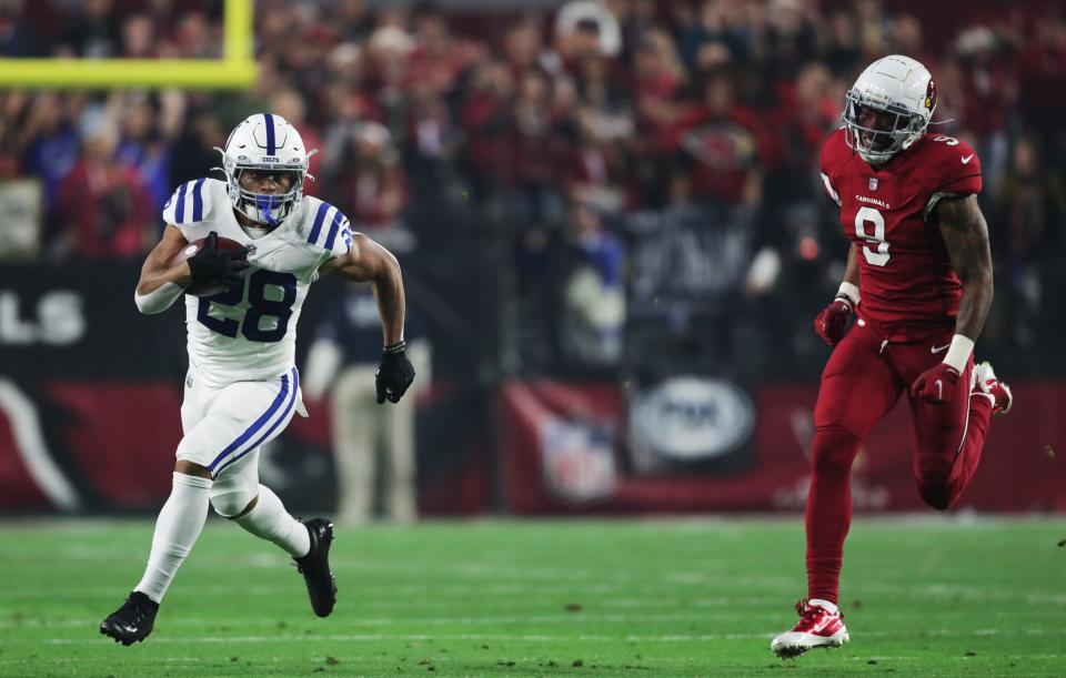Colts running back Jonathan Taylor (28) eludes Cardinals linebacker Isaiah Simmons (9) on a big 43-yard opening run on Dec. 25, 2021.