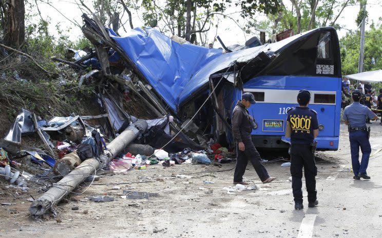 Police officers survey the wreckage from the crash (Picture: AP)