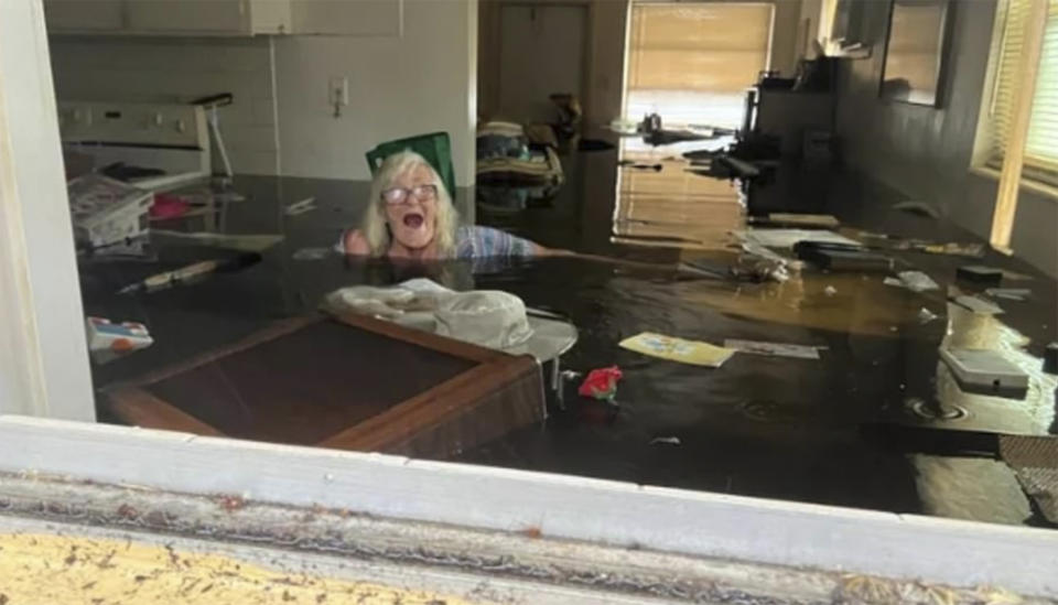 In this photo provided by Johnny Lauder, Lauder's mother, Karen Lauder, 86, is submerged nearly to her shoulders in water that has flooded her home, in Naples, Fla., Wednesday, Sept. 28, 2022, following Hurricane Ian. (Johnny Lauder via AP)