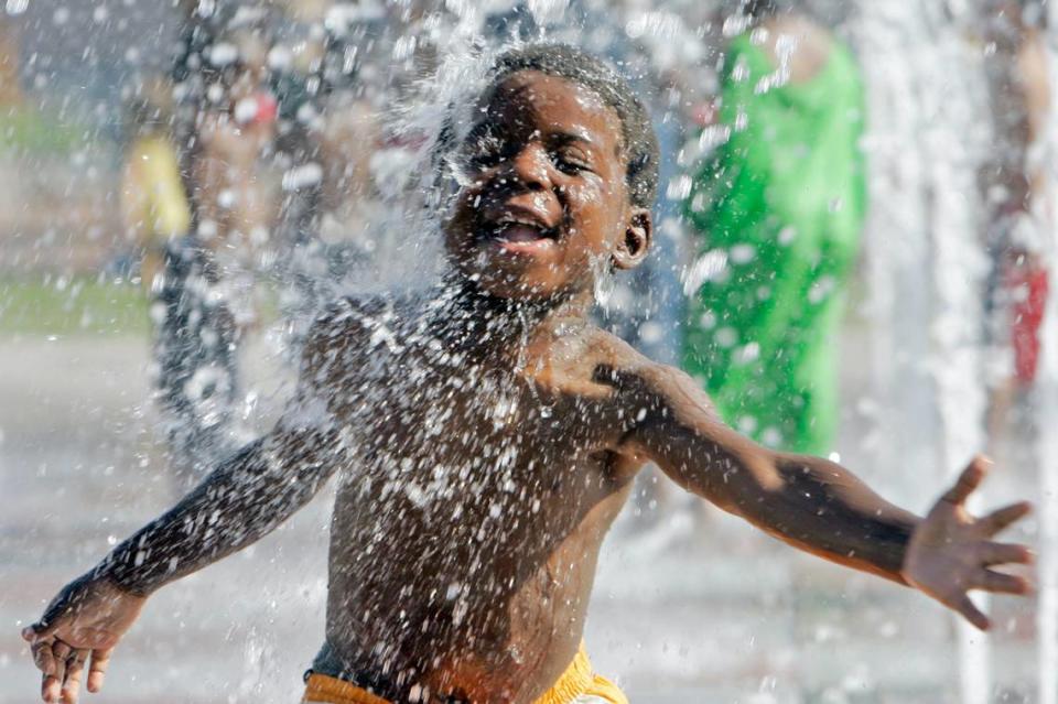 Jamiya Dennis, 4, of Kansas City, reveled in the fountain spray in Crown Center Square. June 18, 2006. CHRIS OBERHOLTZ/\The Kansas City Star